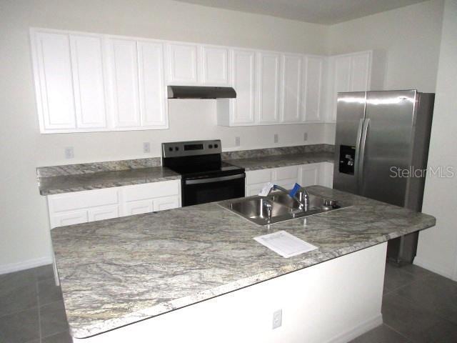 kitchen featuring dark tile patterned flooring, white cabinetry, sink, and appliances with stainless steel finishes