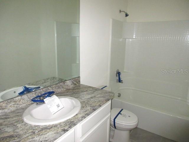 full bathroom featuring tile patterned floors, vanity, toilet, and shower / tub combination