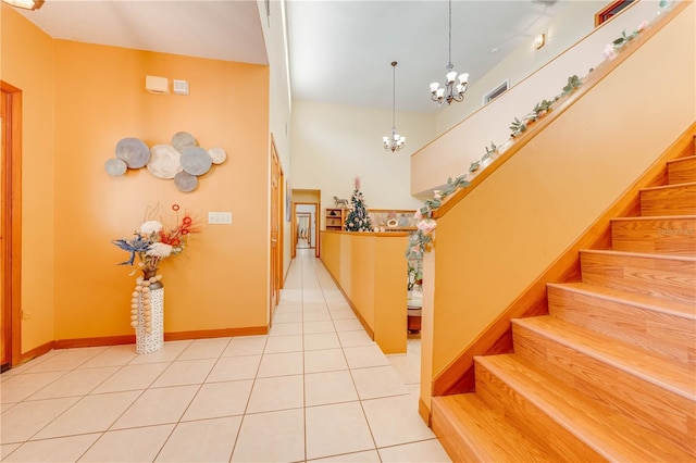 staircase with tile patterned flooring and a chandelier