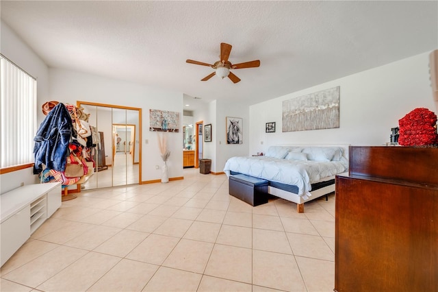 tiled bedroom with ceiling fan and a textured ceiling