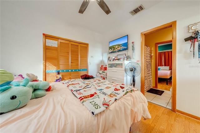 bedroom with light wood-type flooring, a closet, and ceiling fan