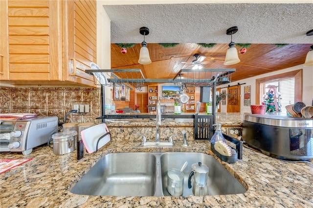 kitchen featuring decorative light fixtures, ceiling fan, sink, and tasteful backsplash