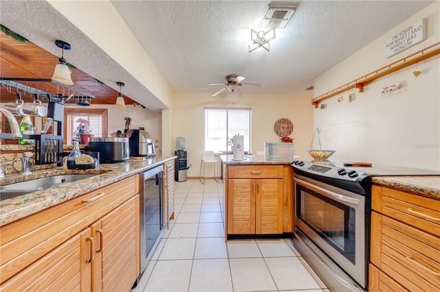 kitchen featuring sink, light tile patterned floors, pendant lighting, a textured ceiling, and stainless steel range with electric cooktop