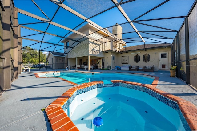 view of pool featuring a patio area, a lanai, and an in ground hot tub