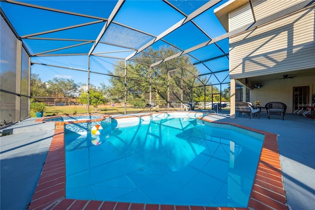 view of pool featuring an in ground hot tub, glass enclosure, ceiling fan, and a patio area