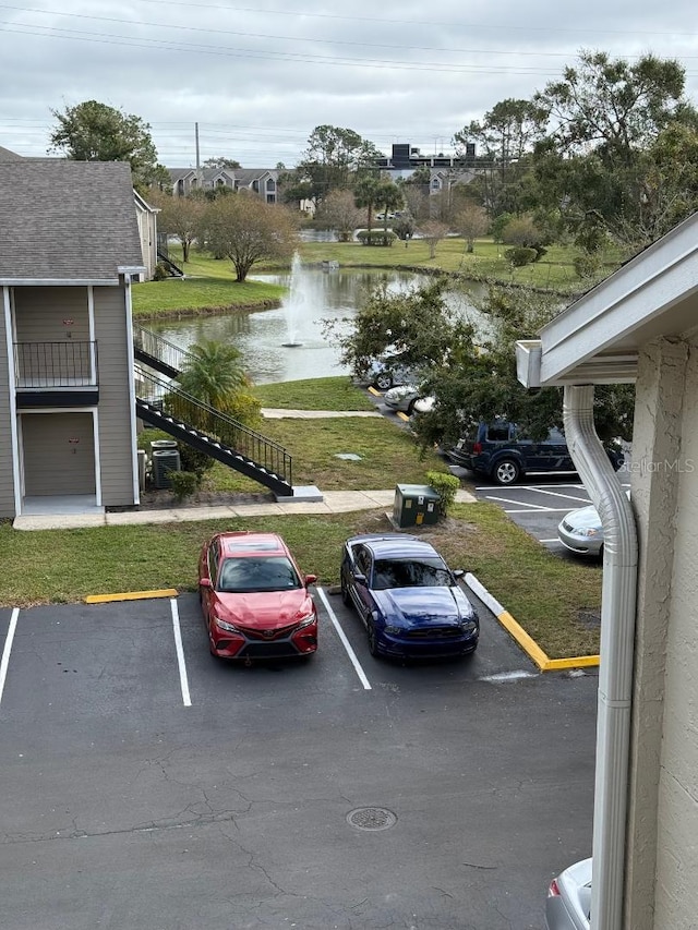 view of car parking featuring a water view