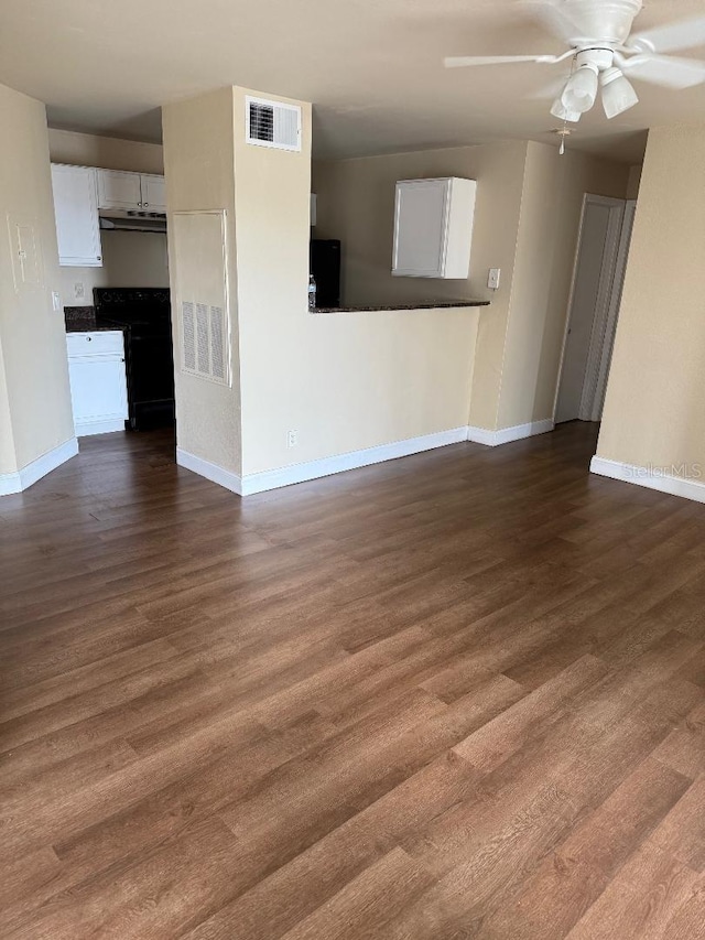 unfurnished living room featuring dark hardwood / wood-style floors and ceiling fan