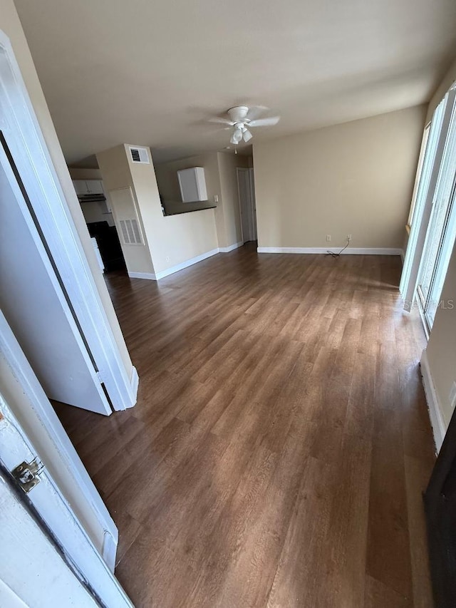 unfurnished living room with ceiling fan and dark hardwood / wood-style flooring