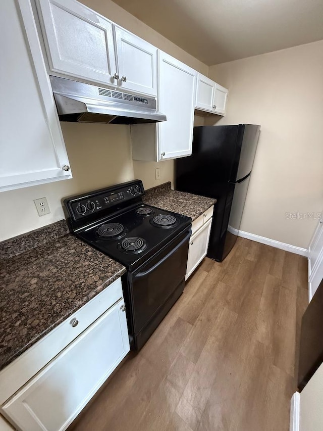 kitchen with white cabinets, light wood-type flooring, dark stone countertops, and black appliances