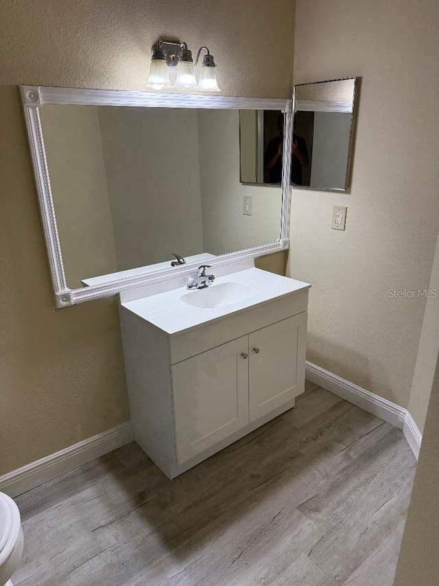 bathroom featuring hardwood / wood-style floors, vanity, and toilet