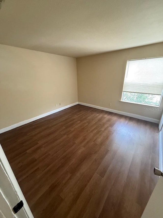 spare room featuring dark hardwood / wood-style floors