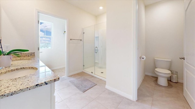 bathroom featuring tile patterned flooring, vanity, a shower with shower door, and toilet