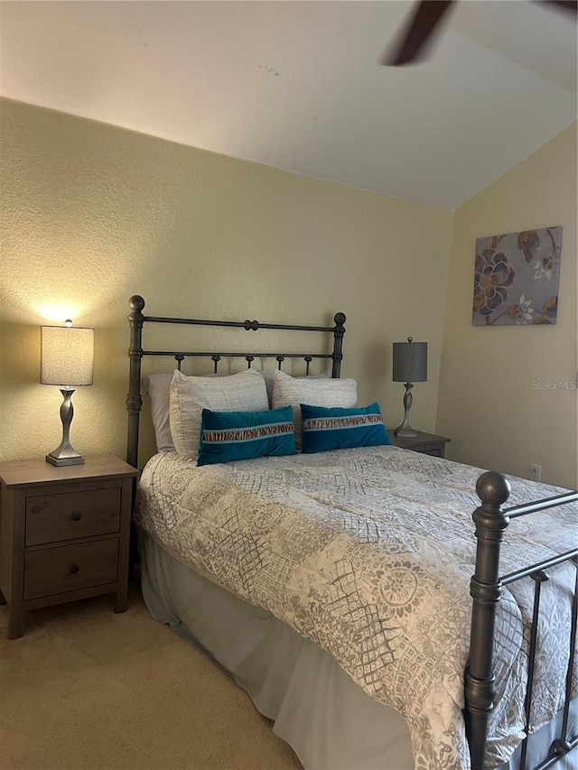 bedroom with ceiling fan, light colored carpet, and lofted ceiling