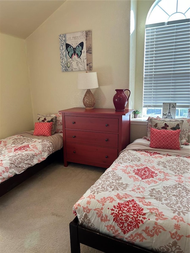 bedroom with carpet flooring and lofted ceiling