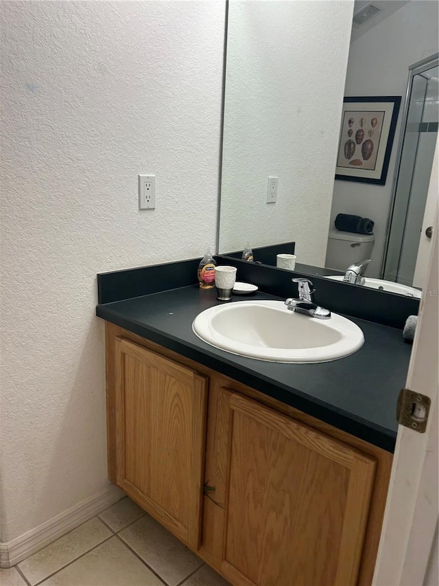 bathroom featuring tile patterned floors, vanity, and toilet