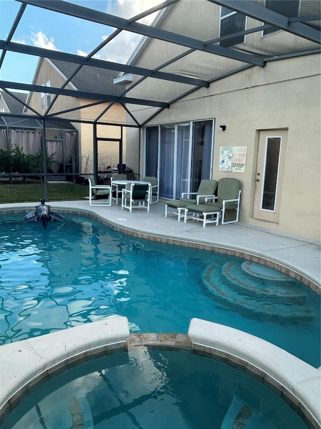 view of pool featuring a lanai, an in ground hot tub, and a patio