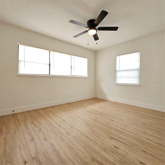 unfurnished room featuring ceiling fan, a healthy amount of sunlight, and light wood-type flooring