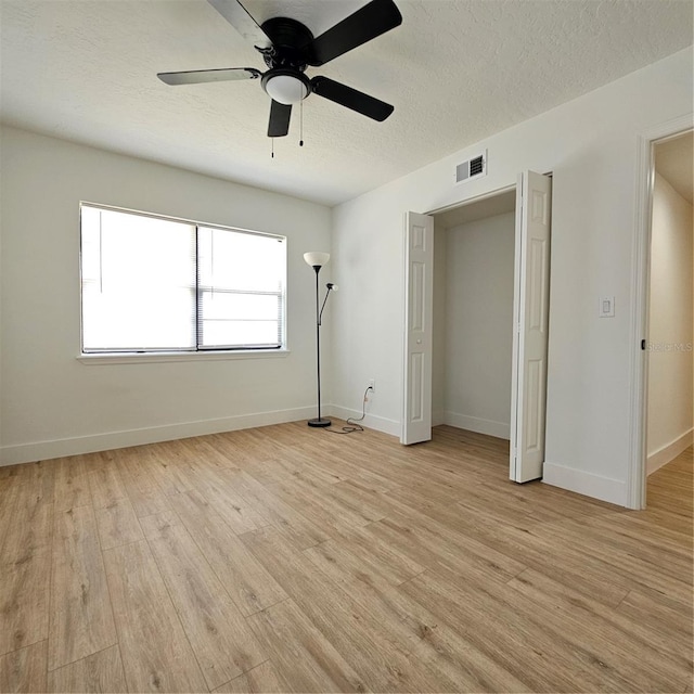 unfurnished bedroom with ceiling fan, light hardwood / wood-style flooring, and a textured ceiling