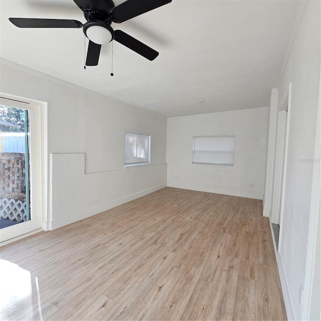 empty room featuring a textured ceiling, ceiling fan, crown molding, and light hardwood / wood-style flooring