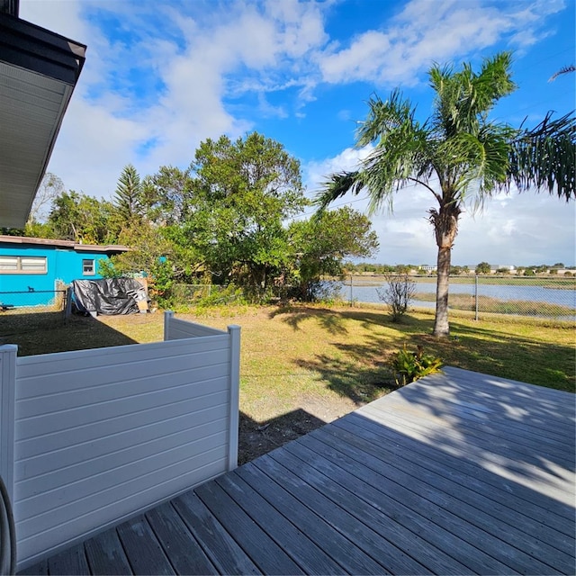 deck with a water view and a lawn