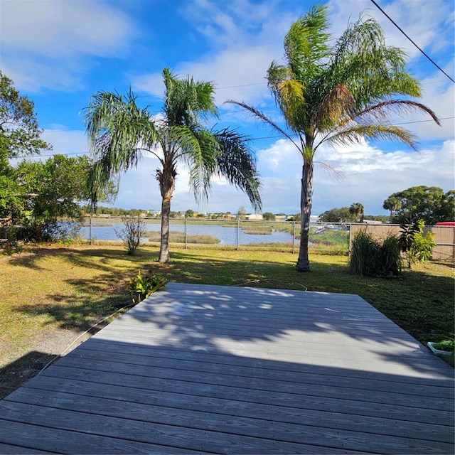 wooden deck featuring a water view and a yard