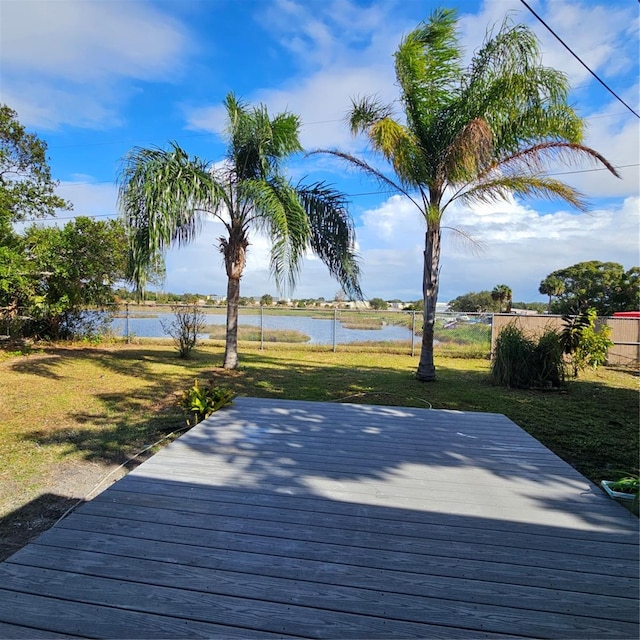 deck with a yard and a water view