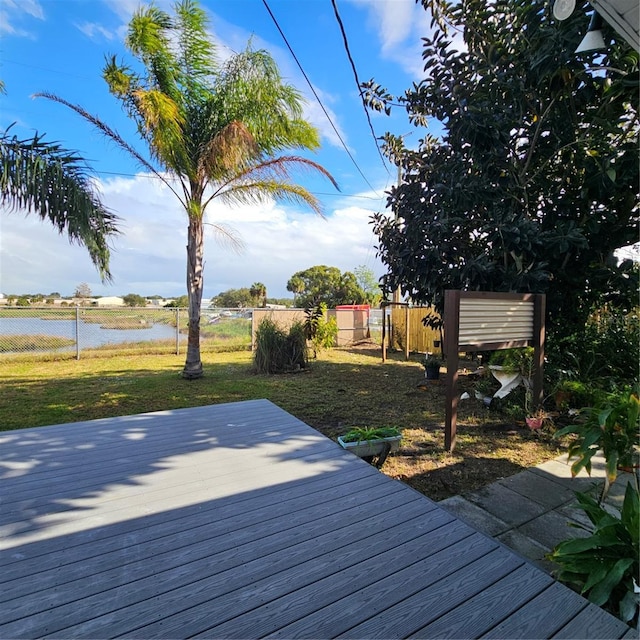 deck with a yard and a water view