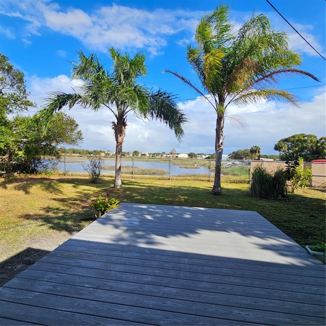 wooden terrace featuring a yard and a water view