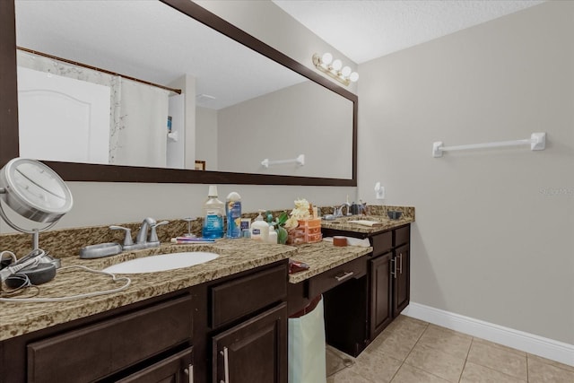 bathroom with vanity, a textured ceiling, and tile patterned floors