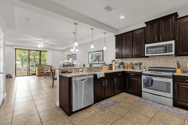 kitchen with kitchen peninsula, pendant lighting, light tile patterned flooring, ceiling fan with notable chandelier, and appliances with stainless steel finishes