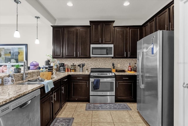 kitchen featuring appliances with stainless steel finishes, tasteful backsplash, sink, light tile patterned floors, and hanging light fixtures