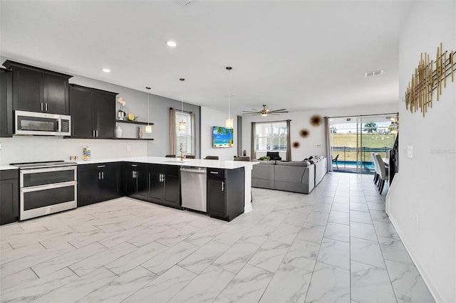 kitchen featuring sink, hanging light fixtures, ceiling fan, kitchen peninsula, and stainless steel appliances