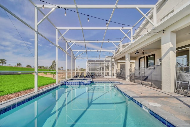 view of pool with a lanai, a patio area, ceiling fan, and an in ground hot tub