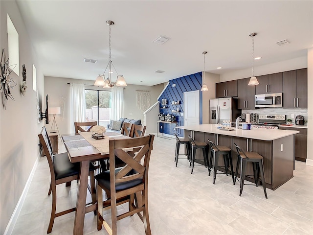 dining area featuring sink and a notable chandelier