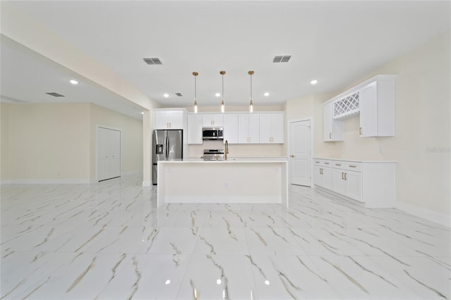 kitchen with stainless steel appliances, white cabinetry, an island with sink, and hanging light fixtures