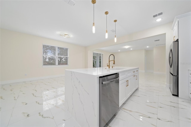 kitchen featuring pendant lighting, white cabinets, sink, an island with sink, and stainless steel appliances