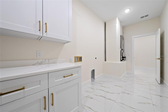 laundry area featuring electric dryer hookup and cabinets