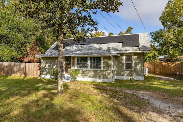 bungalow with solar panels and a front lawn