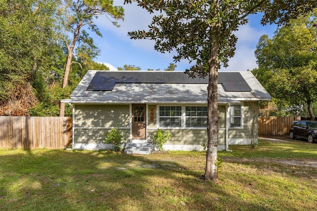 view of front of house featuring solar panels and a front yard