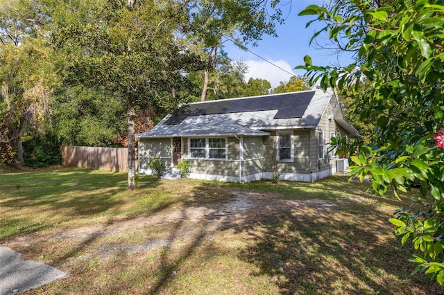 view of outbuilding with solar panels, a yard, and central AC unit