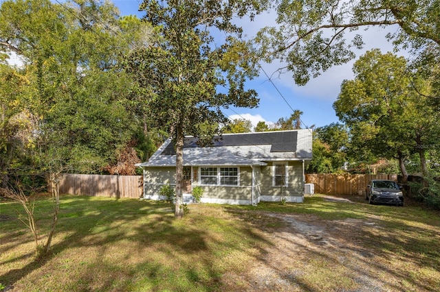 view of front of house with a front yard and solar panels