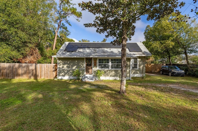 view of front of house with solar panels and a front lawn