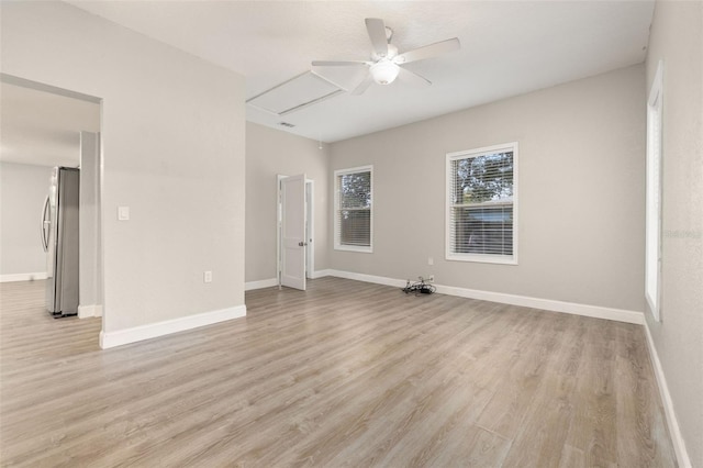 spare room with ceiling fan and light wood-type flooring