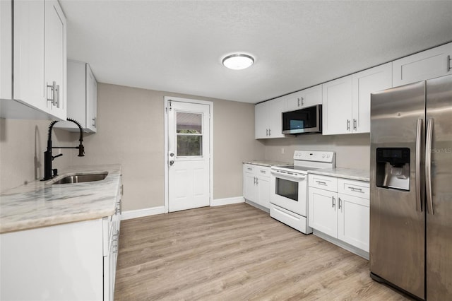 kitchen featuring light stone countertops, stainless steel appliances, sink, light hardwood / wood-style flooring, and white cabinets