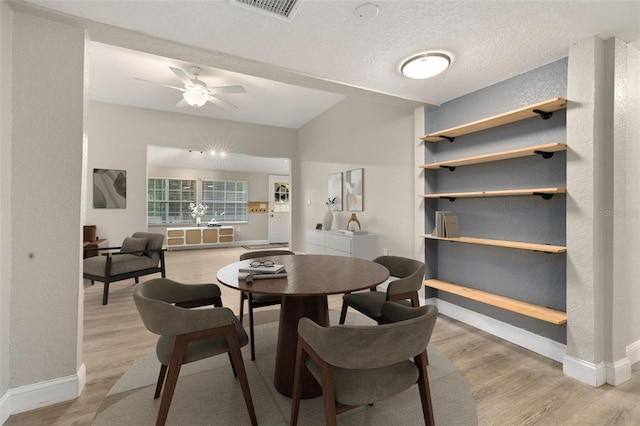 dining area featuring ceiling fan, a textured ceiling, and light wood-type flooring