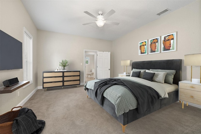 bedroom featuring ceiling fan, light colored carpet, and ensuite bathroom