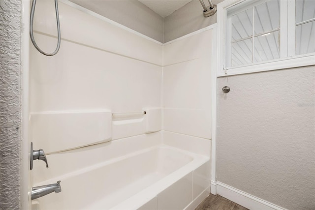 bathroom with hardwood / wood-style flooring and shower / bathtub combination