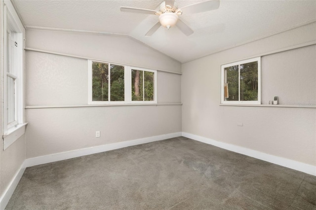 carpeted empty room with ceiling fan, lofted ceiling, and a textured ceiling