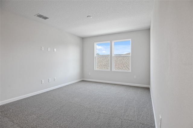 empty room with carpet and a textured ceiling