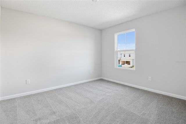 carpeted spare room featuring a textured ceiling